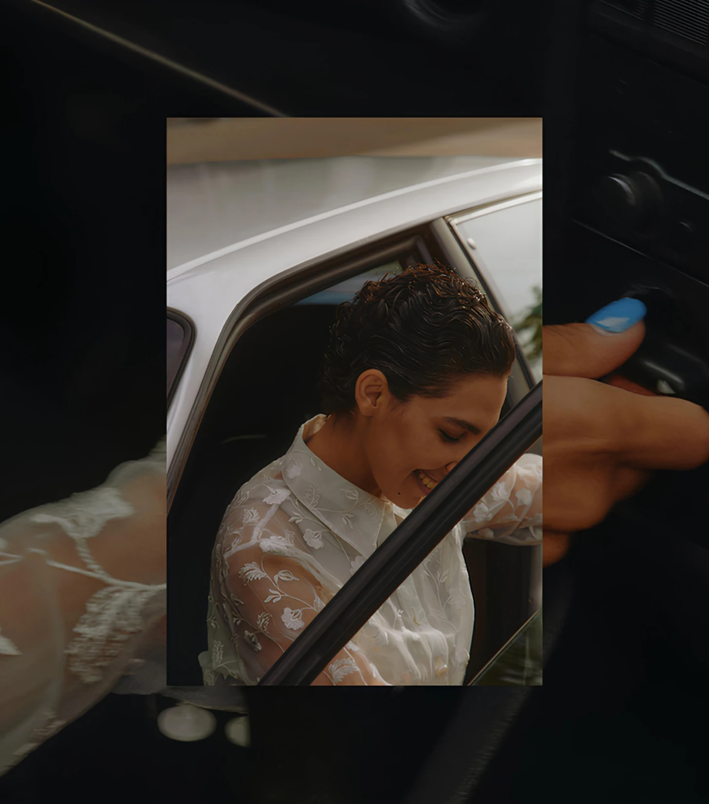 a woman sitting in a car with her hand on the door handle