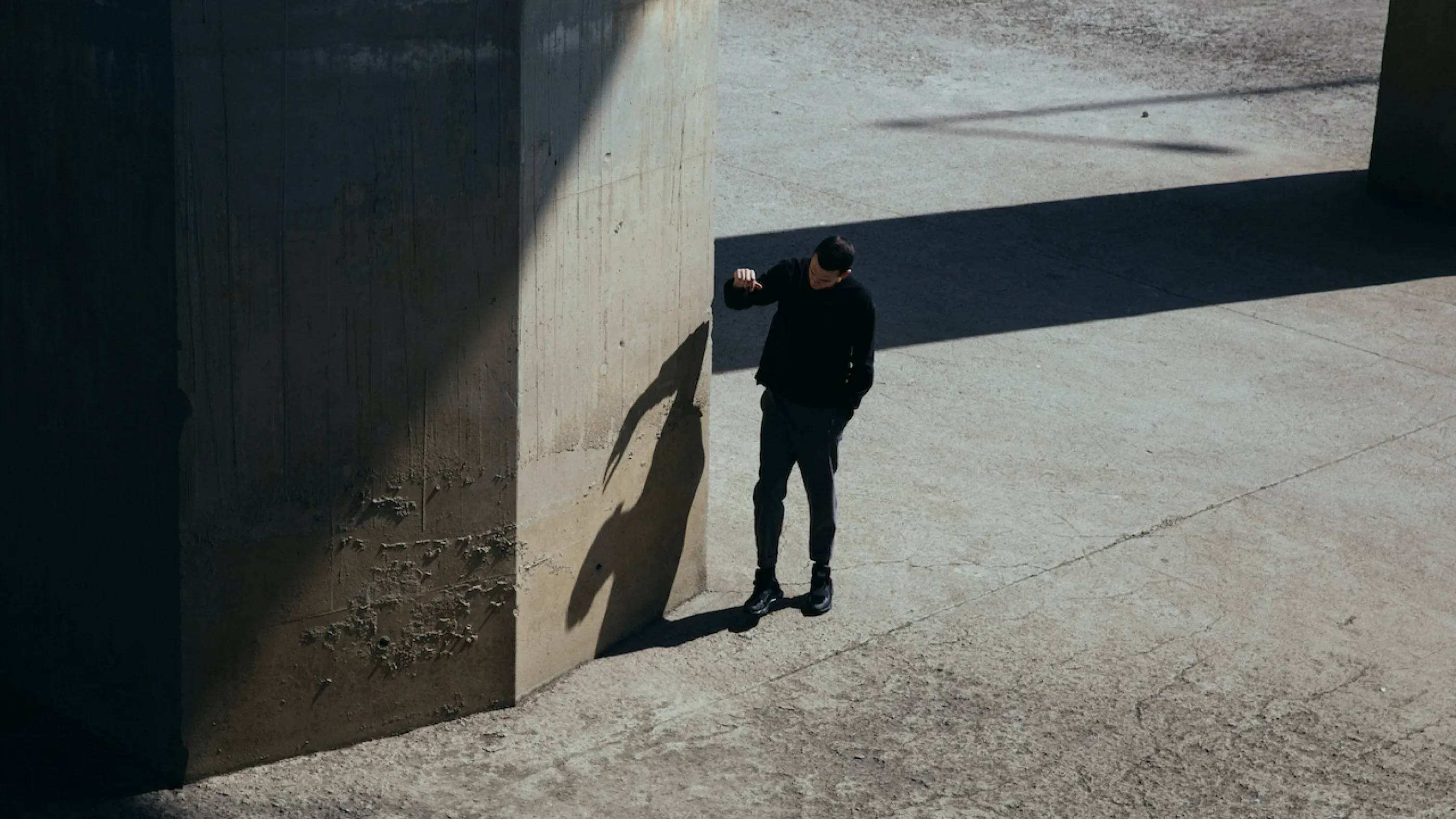 a man standing next to a tall concrete structure